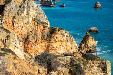 View of idyllic nature landscape with rocky cliff shore and waves crashing on. Camillo beach in...