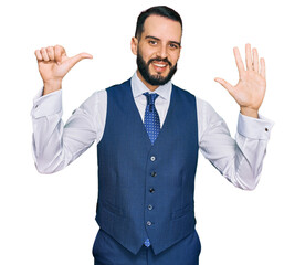 Young man with beard wearing business vest showing and pointing up with fingers number six while smiling confident and happy.