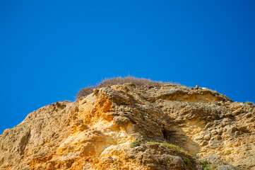 View of idyllic nature landscape with rocky cliff shore and waves crashing on. Camillo beach in Lagos. West Atlantic coast of Algarve region, south of Portugal.