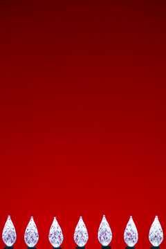 White LED faceted Christmas Lights bottom border against a red verticle background