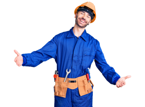 Young hispanic man wearing worker uniform looking at the camera smiling with open arms for hug. cheerful expression embracing happiness.