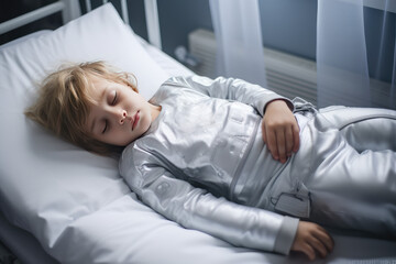 Child boy is sad lying on the bed and holding his stomach. Abdominal pain in children, symptoms of gastritis, poisoning and intestinal infection, abdominal bloating. - obrazy, fototapety, plakaty