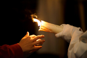 close-up of a child's hands asking a Nazarene for wax