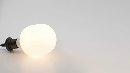 Closeup of led lit light bulb on a grey copy-space surface.