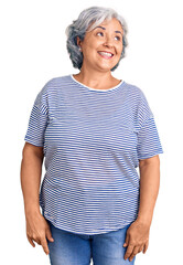 Obraz premium Senior woman with gray hair wearing casual striped clothes looking away to side with smile on face, natural expression. laughing confident.