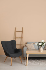 Armchair with couch, ladder and coffee table near beige wall