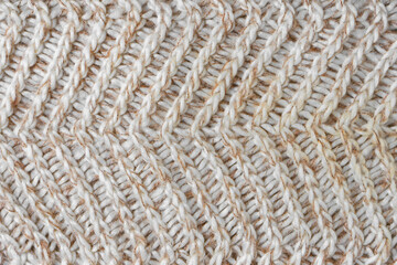 Jersey textile background , beige white melange knitted wool fabric. Woolen knitwear, sweater, pullover surface texture, textile structure, cloth surface, weaving of knitwear material