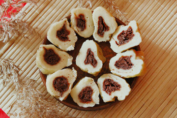 Homemade baked goods - handmade grilled cookies, chopped dumplings, nuts, clay cup of tea on a red background.