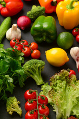 Different fresh vegetables, lettuce and parsley on black background