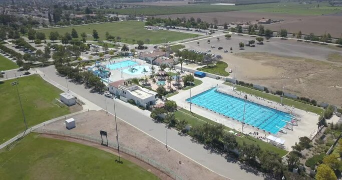 Aerial Orbit of Community Pool & Water Park next to Agriculture Fields