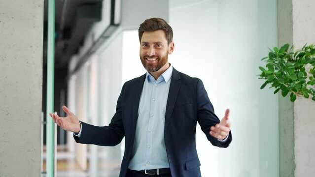 Confident happy business man invites you to join the team near the entrance to the modern business office. An employer, HR entrepreneur, an investor calls to invest or hire look at the camera. Join Us