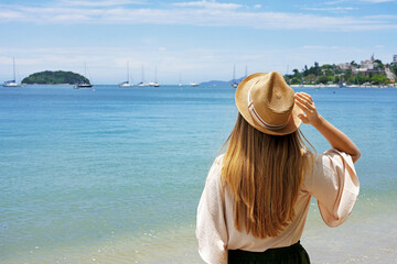 Holidays on tropical island. Traveler girl on Jurere beach, Florianopolis Island, Brazil.