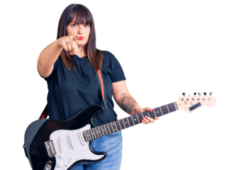 Young plus size woman playing electric guitar pointing with finger to the camera and to you, confident gesture looking serious