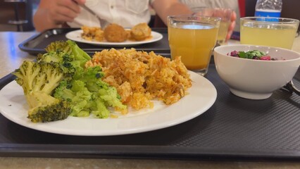 Broccoli with a dish of pilaf on the table while dining with friends.