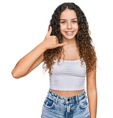 Teenager hispanic girl wearing casual clothes smiling doing phone gesture with hand and fingers like talking on the telephone. communicating concepts.