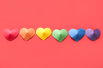 Colorful hearts made of paper on red background. LGBT concept