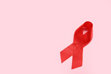 Red ribbon on pink background. AIDS Day concept