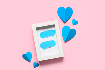 Composition with picture frame and paper hearts on pink background. Valentines Day celebration