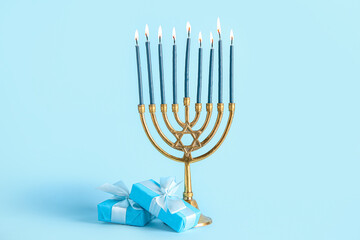 Menorah with gift boxes on blue background. Hanukkah celebration