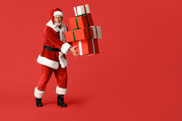 Santa Claus with many gift boxes on red background