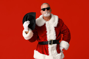 Santa Claus in stylish hat on red background