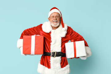 Happy Santa Claus with gift boxes on blue background
