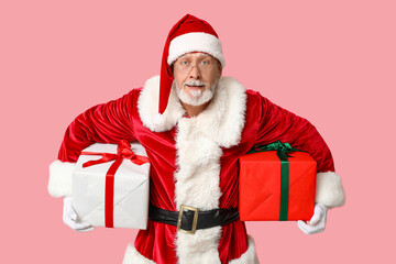 Cool Santa Claus with gift boxes on pink background