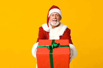 Cool Santa Claus with gift box on yellow background