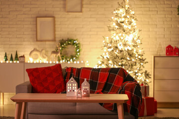 Interior of stylish living room with beautiful Christmas tree and gift boxes at night