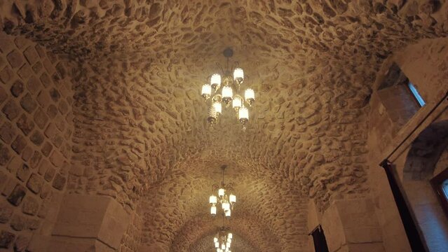Cross-vaulted ceiling of one of Turkey's oldest protestant churches in Mardin. Stylish chandeliers and stone workmanship can be seen.