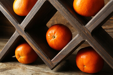Stand with sweet mandarins on wooden background