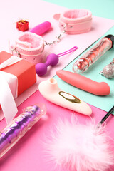 Composition with different sex toys, Christmas gift and decorations on color background, closeup
