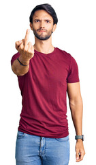 Handsome hispanic man wearing casual clothes showing middle finger, impolite and rude fuck off expression