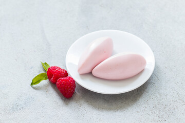 Raspberry cream dessert quenelle, on a plate. Copy space