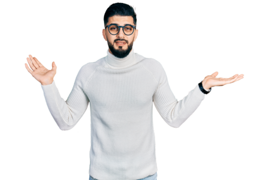 Young arab man with beard wearing elegant turtleneck sweater and glasses clueless and confused expression with arms and hands raised. doubt concept.