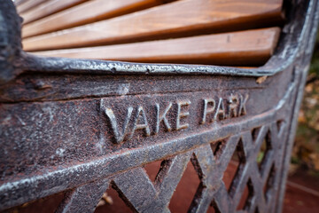 VAKE PARK embossed lettering on the metal detail of the vintage style park bench, close up shot.