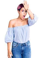 Fototapeta premium Young beautiful woman with pink hair wearing casual clothes surprised with hand on head for mistake, remember error. forgot, bad memory concept.