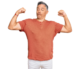 Handsome middle age man wearing casual clothes showing arms muscles smiling proud. fitness concept.