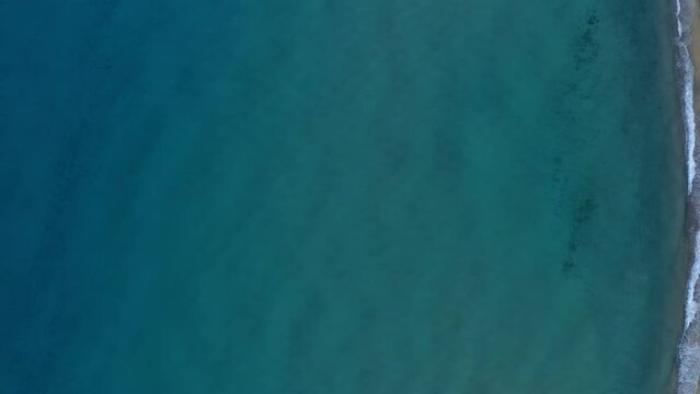 Drone top aerial view of Solanas beach with turquoise water, camper vans and mountain landscape in Sardinia, Italy