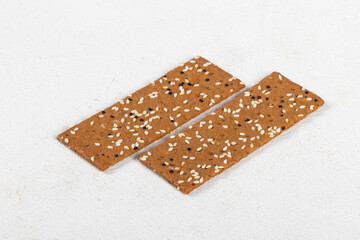 Two Buckwheat breads with sesame seeds and quinoa, in the form of thin strips. White background. Close up