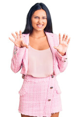 Young beautiful latin girl wearing business clothes smiling funny doing claw gesture as cat,...