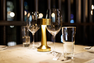 A romantic table setting with wine glasses and a gold candlestick in a cozy restaurant