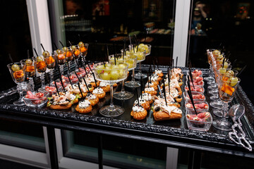 A variety of savory and sweet snacks on a black and silver platter