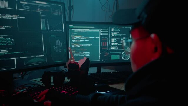 Asian hacker typing quickly on keyboard at dark room