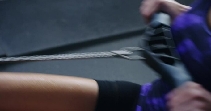 Woman, fitness and rowing machine for workout, exercise or indoor training in cardio at gym. Closeup of female person or athlete pulling rope or equipment in row to lose weight or health and wellness