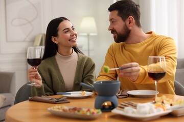 Affectionate couple enjoying fondue during romantic date at home