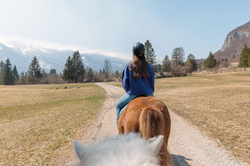 Young woman riding Icelandic horse in nature at spring.