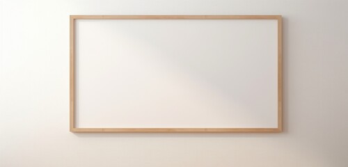 The lens captures a modern wooden frame hanging on a beige wall, showcasing an empty canvas. The empty mockup radiates a modern and clean aesthetic.