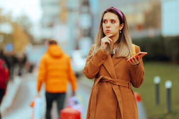 Confused Woman Checking her Phone Walking on the Street. Puzzled lady thinking about the direction holding navigation app
