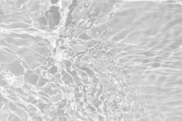 White water with ripples on the surface. Defocus blurred transparent white colored clear calm water surface texture with splashes and bubbles. Water waves with shining pattern texture background.